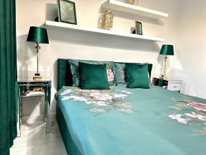 1 dormitorio con 1 cama con sábanas y almohadas verdes en LuxApart Kalisz New en Kalisz