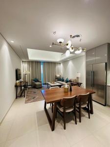 a dining room and living room with a wooden table at Ocean Mountain View Apartment at The Address Fujairah in Fujairah