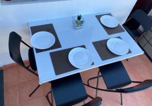 ein Tisch und Stühle mit weißen Platten drauf in der Unterkunft Villa Mogan Mall, con jacuzzi y PlayStation 5 in Puerto Rico de Gran Canaria