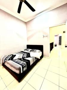 Grand Homestay Kulim 4-Bedroom في Lunas: غرفة نوم بسريرين ومروحة سقف