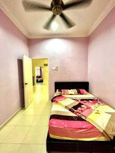 Grand Homestay Kulim 4-Bedroom في Lunas: غرفة نوم بسرير ومروحة سقف