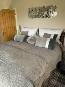 a bedroom with a large bed with many pillows at Old Manse Cottage in Durness