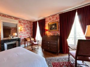 PichenyにあるChâteau de Pichenyの赤い壁紙のベッドルーム1室、ベッド1台、デスクが備わります。