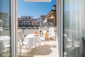 a balcony with a table and chairs on a balcony at Hotel Pigalle in Lido di Jesolo