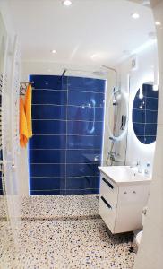 a blue bathroom with a sink and a mirror at Luksusowy Apartament Nad Zalewem in Serock
