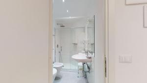 bagno bianco con servizi igienici e lavandino di Hotel Ligure a Spotorno