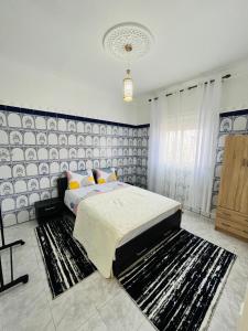 1 dormitorio con 1 cama y una pared azul y blanca en Joli appartement avec patio, parking et toit terrasse Nice apartment with patio, parking and rooftop en Marrakech