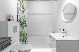 a bathroom with a sink and a toilet and a mirror at Chill Apartments Praga Południe in Warsaw +52 photos
