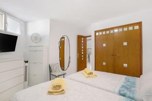 a bedroom with two beds and a door with a mirror at Los Geranios 407 in Adeje +15 photos
