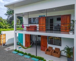 a house with wooden doors and a balcony at Villas Mapache del Caribe in Puerto Viejo