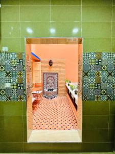 a bathroom with a fireplace and a green wall at Joli appartement avec patio, parking et toit terrasse Nice apartment with patio, parking and rooftop in Marrakesh