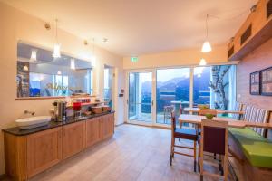 a kitchen with a counter and a table with chairs at Hotel Alpenwelt Superior in Flachau