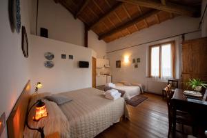 sypialnia z 2 łóżkami i stołem w pokoju w obiekcie Campanacci Agriturismo w mieście Faenza
