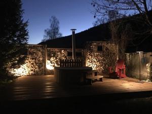 un patio nocturno con un banco y un edificio de piedra en Gites de la Planta, en Le Bouilly