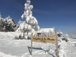 un panneau dans la neige devant une maison dans l'établissement Gites de la Planta, à Le Bouilly