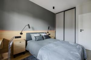 a bedroom with a large bed with a desk and a bed sidx sidx sidx sidx at Apartament Manufaktura Centrum z klimatyzacją in Łódź