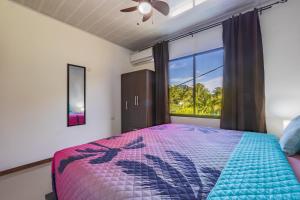 ein Schlafzimmer mit einem Bett und einem großen Fenster in der Unterkunft Villas Mapache del Caribe in Puerto Viejo