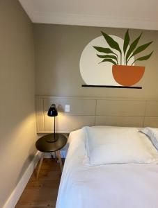 una camera da letto con un letto e una pianta sul muro di Pousada Telhado de Ouro a Campos do Jordão