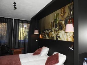 a bedroom with a bed and a painting on the wall at hotel de Tipmast in Bladel