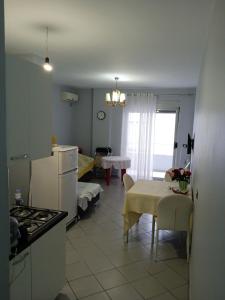 a kitchen and living room with a table and a stove at Apartment Durres in Durrës
