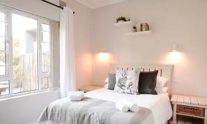 a bedroom with a bed and a large window at Amblewood Beach Cottages in Kenton on Sea