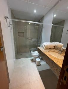 e bagno con doccia, servizi igienici e lavandino. di Pousada Telhado de Ouro a Campos do Jordão