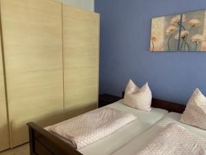 a bedroom with two beds and a painting on the wall at Ferienwohnung am Markt 2 in Annaberg-Buchholz