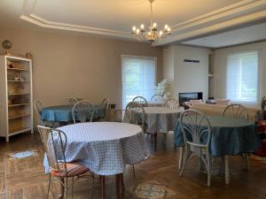 comedor con mesas y sillas y TV en Chambres d’hôtes Nordlys, en Pluneret