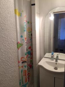 Un baño con lavabo y cortina de ducha. en Le Cocon, en Luchon