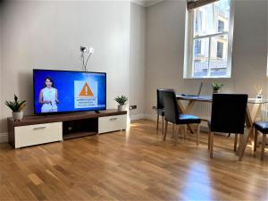 a living room with a tv and a table with chairs at Sight Flats - SF01 - One Bedroom in London