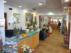 a lobby of a store with two people sitting at a counter at Hotel Venezia in Caorle