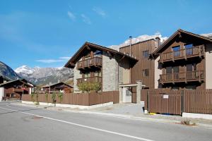 a building with a fence on the side of a street at Olympic Chalet 12 13 in Bormio