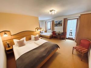 a hotel room with a large bed and a table at Gästehaus Achental in Berchtesgaden