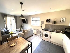 a living room with a kitchen and a living room with a washing machine at Perfect for contractors 2 bedroom- 2 bathrooms- 4 single beds- free parking in Southampton