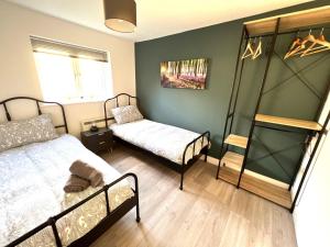 a bedroom with two beds and a window at Perfect for contractors 2 bedroom- 2 bathrooms- 4 single beds- free parking in Southampton
