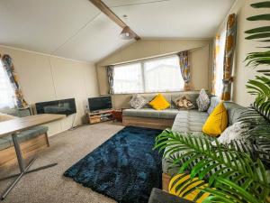 a living room with a couch and a tv at Lovely 6 Berth Caravan At Seaview Holiday Park In Kent Ref 47001d in Whitstable