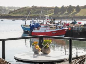 a table with two plants on it with a boat in the water at The Other 43 in Kinsale