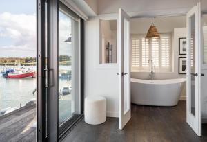 a bathroom with a tub and a view of the water at The Other 43 in Kinsale