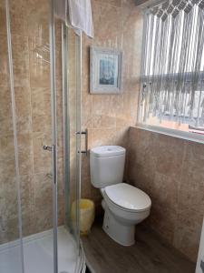 a bathroom with a toilet and a glass shower at The Boho - 4 min walk to beach & town in Bournemouth