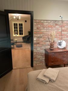 a bedroom with a brick wall and a bed and a mirror at Nice apartment close to the sea with parking and garden in Arendal