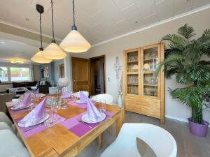 a dining room with a wooden table and white chairs at Ferienhaus SweetDreams in Bad Sachsa