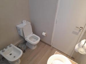 a white bathroom with a toilet and a sink at Hotel TOTEM Boutique in Termas de Río Hondo +17 photos