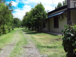 un camino de tierra junto a una casa con árboles en Turismo Merino Depto El Paraiso en San Rafael