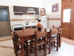 una cocina con una mesa de madera con sillas alrededor. en Turismo Merino Depto El Paraiso en San Rafael