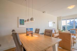 a kitchen and dining room with a wooden table and chairs at Appartementencomplex Juliana 52 in De Koog