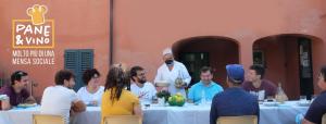 um grupo de pessoas sentadas em torno de uma mesa com um chef em QOELET - B&B Etico e Sociale em Montevarchi