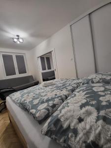 a bedroom with a bed with a blue and white comforter at Apartament przy Lipowej in Białystok