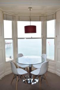 a dining room with a table and chairs and a view of the ocean at Beautiful Seafront 1 bedroomed apartment in Aberystwyth