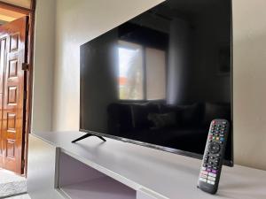 a remote control sitting on a table next to a television at Spacious 3 Bedroom Apartment Excellent Location Bugolobi Kampala - Immersion 1 in Kampala