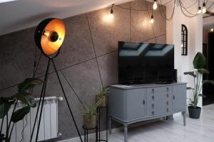 una lámpara en un tocador con un televisor. en Loft Parkowa, en Przemyśl